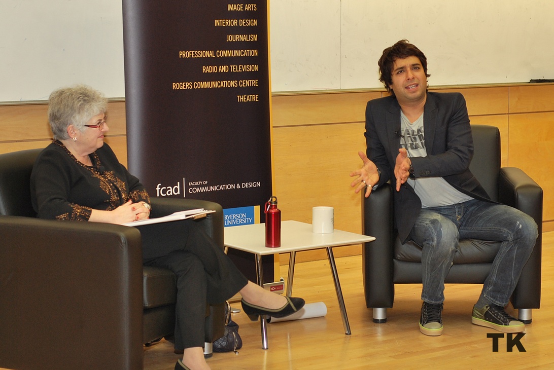 Two people in professional interview or discussion setting with educational banner showing Faculty of Communication & Design programs including Theatre, Professional Communication, and other media-related fields.