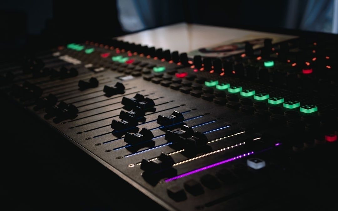Close-up of a sound mixing console with illuminated controls